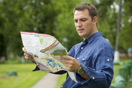 Young male tourist with map in hand looking around. Tourist map of the city of Moscow, Russia (no...