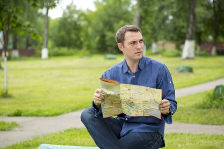 Young male tourist with map in hand looking around. Tourist map of the city of Moscow, Russia (no...