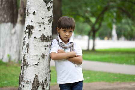Portrait of adorable and fashionable little boy outdoor at the nice summer day