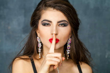 Beautiful Brunette Girl with hairstyle and make up isolated on dark wall backgroundの写真素材