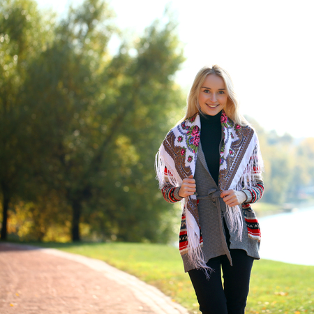 Portrait close up of young beautiful woman, on background autumn park