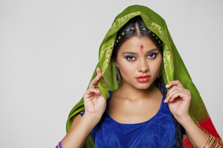 Young beautiful brunette woman in indian green dressの写真素材