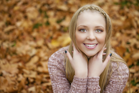 Portrait close up of young beautiful blonde women, on golden background autumn natureの写真素材