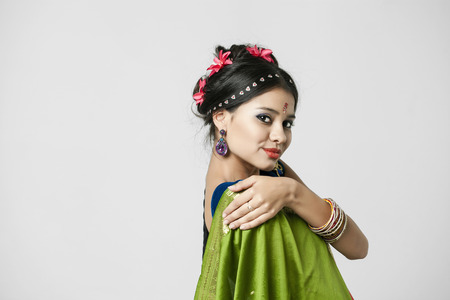 Young beautiful brunette woman in indian green dressの写真素材