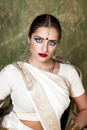 Young beautiful brunette woman in indian white dressの写真素材