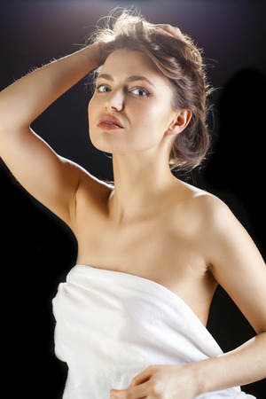 Beauty woman face closeup isolated on black background. Beautiful model girl makeup. Gorgeous sexy brunette lady touching her skin. Perfect make upの写真素材