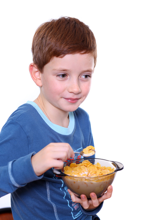 Little boy breakfast isolated over white backgroundの写真素材
