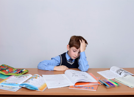 beautiful little boy sitting at the tableの写真素材