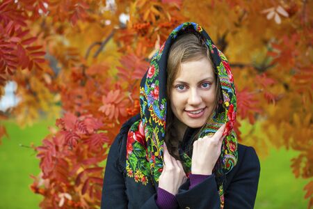 Portrait of young Italians in a beige coat and knit a scarf on her headの写真素材