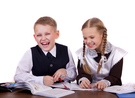 A couple of elementary school students sit at a desk, isolated on whiteの写真素材