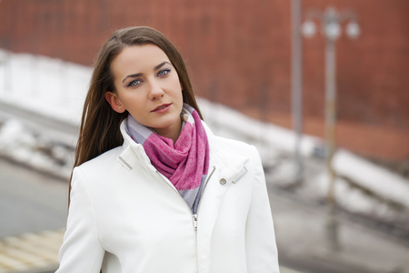 Portrait close up of young beautiful brunette woman, on spring street backgroundの写真素材