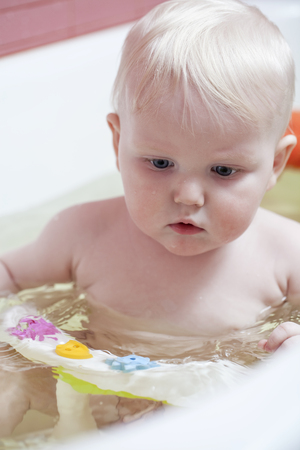 Adorable bath baby in bathroomの写真素材