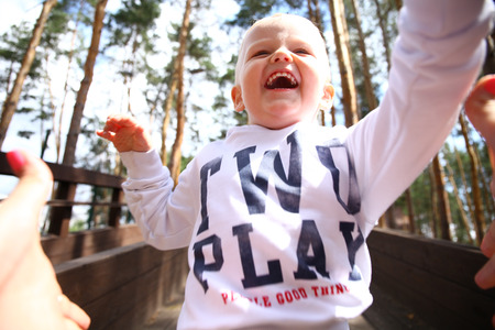 Portrait of blonde baby boy running in summer forestの写真素材