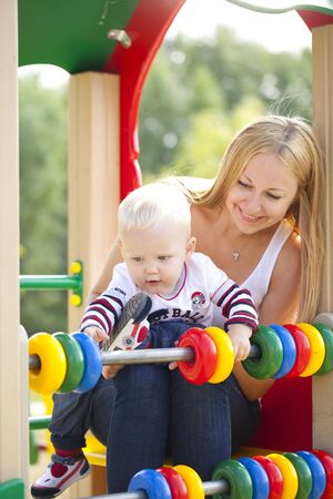 Young mother with two year old son on the playgroundの写真素材