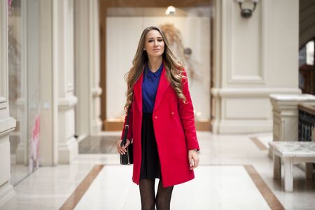 Portrait close up of young beautiful blonde woman in red coatの写真素材