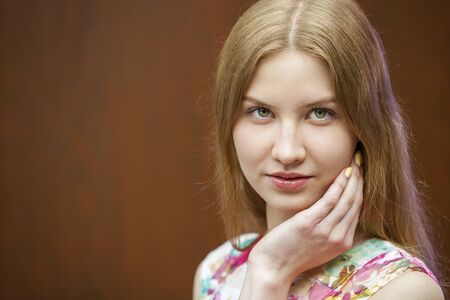 Young beautiful blonde woman on the background of wooden wallの写真素材