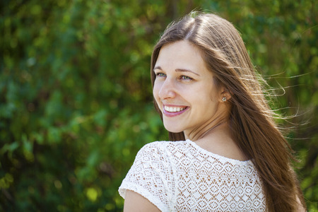 Close up portrait of beautiful young happy brunette woman with fresh and clean skin, summer street outdoorsの写真素材