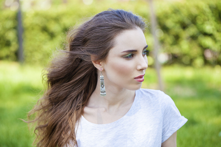 Close up portrait of beautiful young happy brunette woman with fresh and clean skin, summer street outdoorsの写真素材