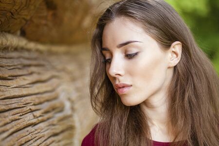 Portrait of a beautiful young woman on a background of old wooden wallの写真素材