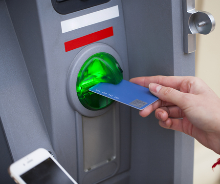 Female arms Take cash from the ATM, close upの写真素材