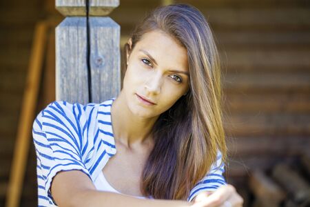 Portrait of a beautiful young woman on a background of old wooden wallの写真素材