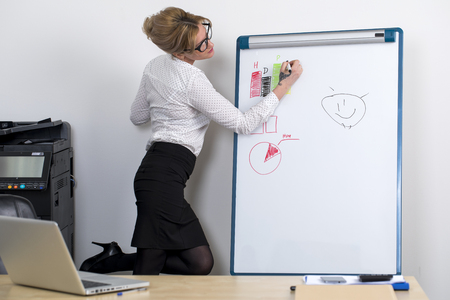 Sales draws a graph on the board for inscriptions at the officeの写真素材