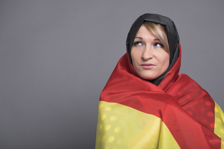 Young beautiful woman wrapped in the German flagの写真素材