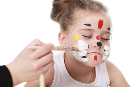 Happy beautiful little girl with painted face, isolated on white backgroundの写真素材
