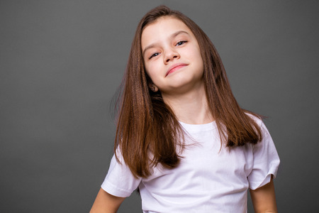 Portrait of a charming little girl, isolated on gray backgroundの写真素材