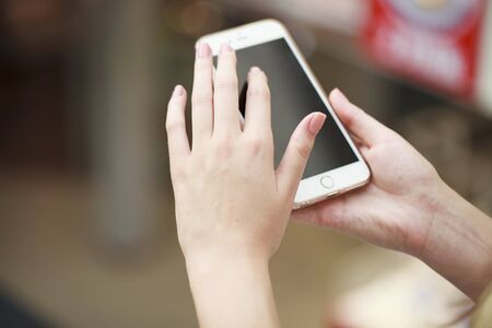 Beautiful female hands holding a mobile phone, indoor
