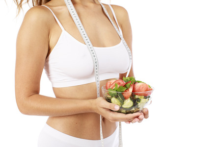 Dietary salad and slender female figure in sports white lingerie, isolated over white backgroundの写真素材