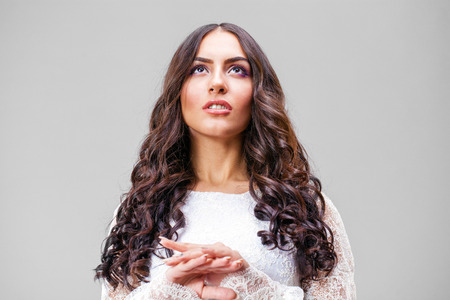 Close up face. Young arabic woman in white sexy dress, isolated on gray backgroundの写真素材