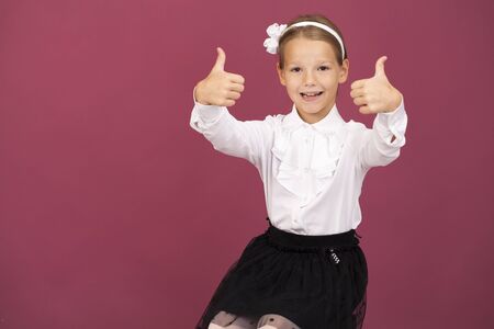 Portrait of young beautiful blonde woman showing thumbs up, isolated on plum backgroundの写真素材