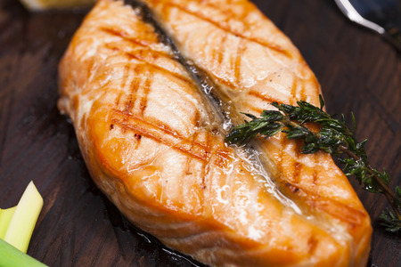 Glazed salmon fillet with sesame close-up on a wooden plateの写真素材