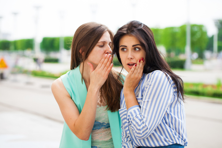 Two young women talking to each other. Girl friends having a chat.の写真素材