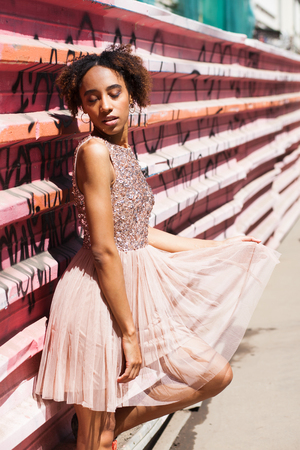 Street fashion model. Portrait of an African young woman in pink dressの写真素材