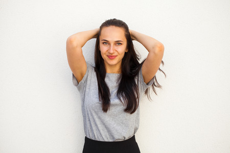 Happy Beautiful brunette woman in gray t-shirt, isolated on white wall background