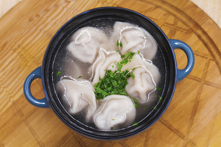 Russian national dish - boiled dumplings with broth in a white cupの写真素材