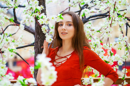 Close up portrait women. Young beautiful brunette model in red dress, indoor shopの写真素材