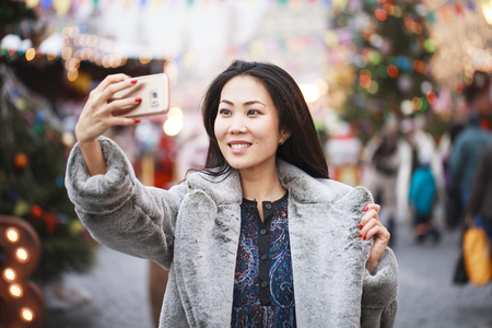 Chinese tourist photographs himself on a cell phone on the red square on the eve of the new yearの写真素材