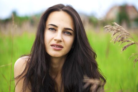 Close up portrait of beautiful young happy brunette woman with fresh and clean skin, summer street...