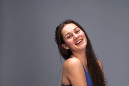 Beautiful brunette woman face close up portrait studio isolated on gray backgroundの写真素材
