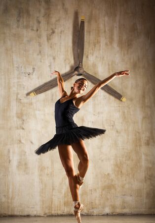 Black Swan - Portrait of a young beautiful ballerina in black ballet tutu posing in studioの写真素材