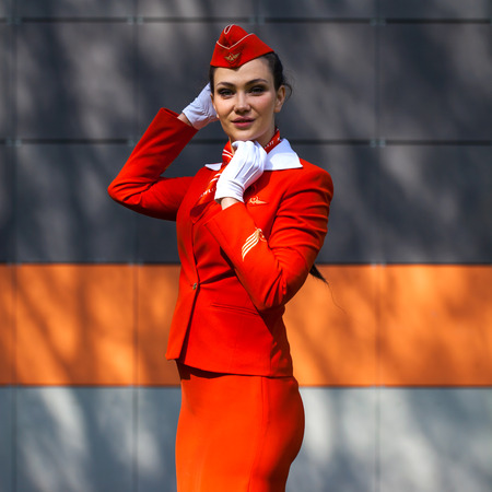 RUSSIA, SAMARA: 08 AUGUST 2019. Beautiful stewardess dressed in official red uniform of Aeroflot Airlines, Summer street outdoorsのeditorial素材