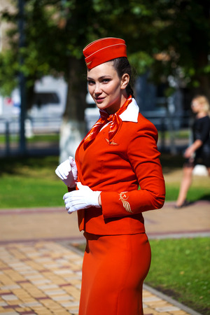 RUSSIA, SAMARA: 08 AUGUST 2019. Beautiful stewardess dressed in official red uniform of Aeroflot Airlines, Summer street outdoorsのeditorial素材