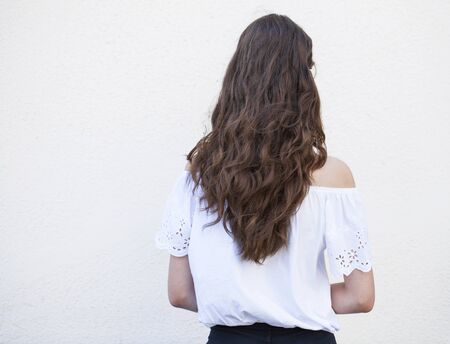 Female Long brunette hair, rear view, on studio wall backgroundの写真素材