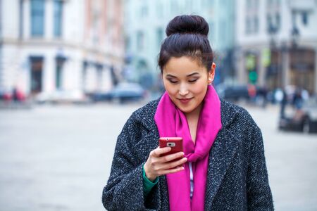 Happy beautiful asian woman calling by phone on the spring streetの写真素材