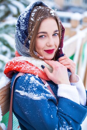 Happy young woman in blue coat posing in winter streetの写真素材