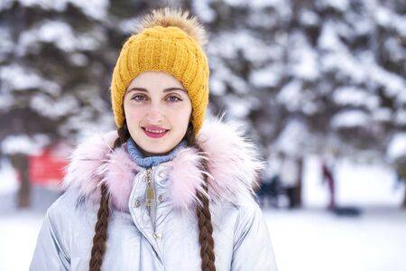 Closeup portrait of a young beautiful girl in winter park
