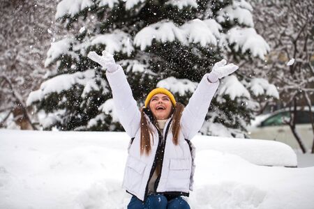Snowfall. Young beautiful girl in a winter park